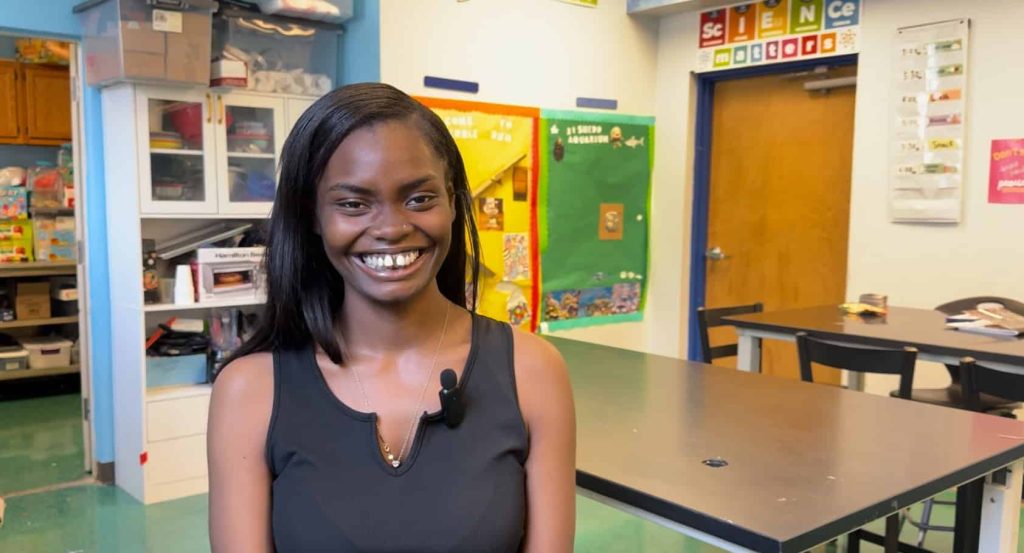 Swift smiles sitting in front of the camera in a Youth Science Pathways program classroom.